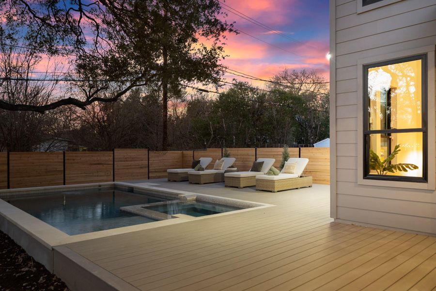 View of swimming pool featuring a fenced backyard, a deck, and a pool with connected hot tub