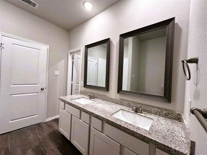 Double sinks, granite counters, framed mirrors- this master bath has it all!