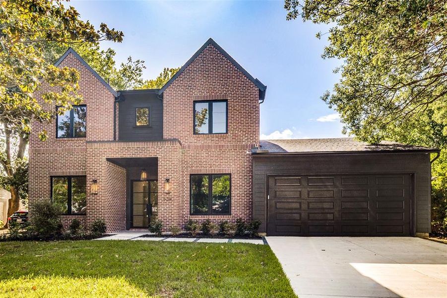 Contemporary brick facade featuring dark framed windows and a prominent entryway Contemporary brick facade featuring dark framed windows and a prominent entryway