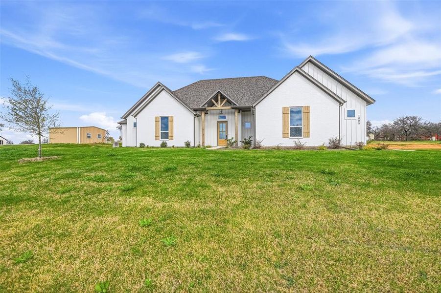 Modern farmhouse featuring board and batten siding and a front yard