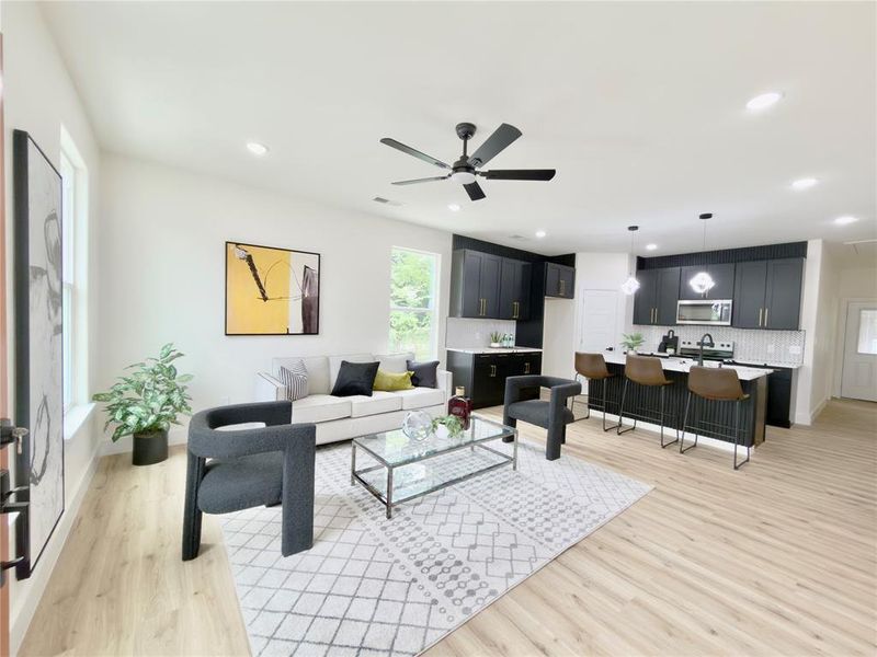 Open-concept living space featuring wood-finish flooring, recessed lighting, and a ceiling fan