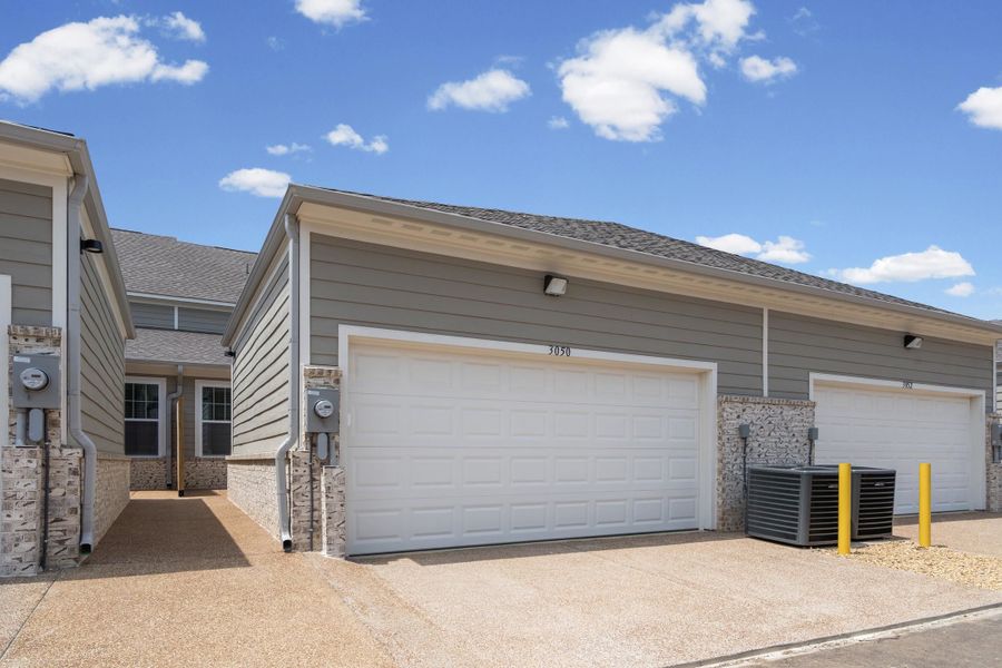 Attached garage featuring a white door and gray siding