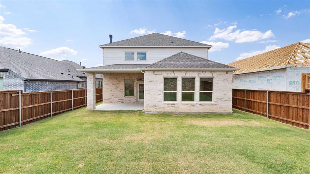 Back of property with a yard and a patio area