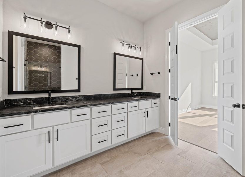 Full bathroom featuring tiled shower, double vanity, and a sink Full bathroom featuring tiled shower, double vanity, and a sink