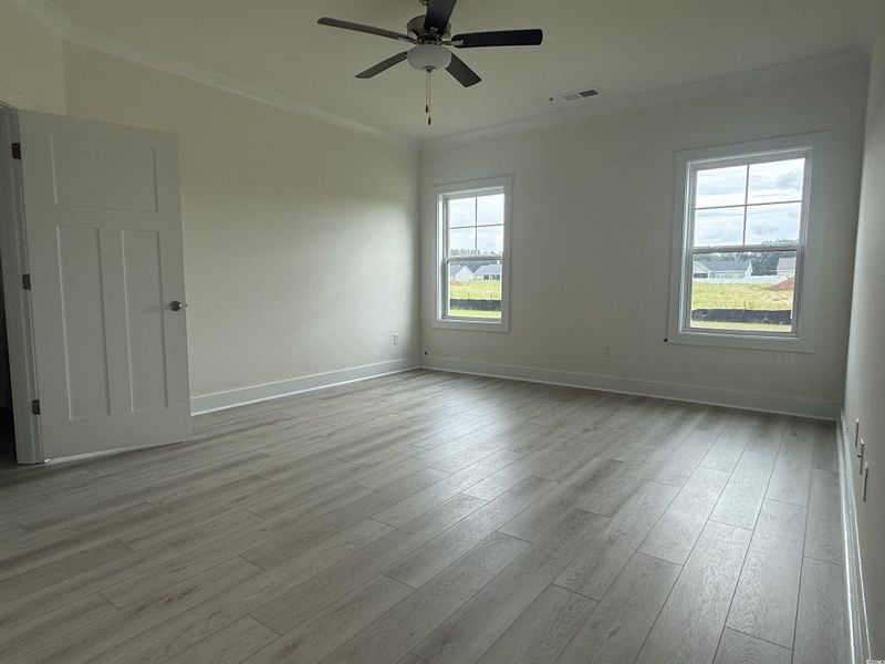 Unfurnished room featuring ornamental molding, light wood finished floors, and a ceiling fan