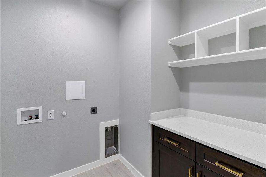 Laundry room featuring cabinets, hookup for a gas dryer, washer hookup, hookup for an electric dryer, and light hardwood / wood-style floors