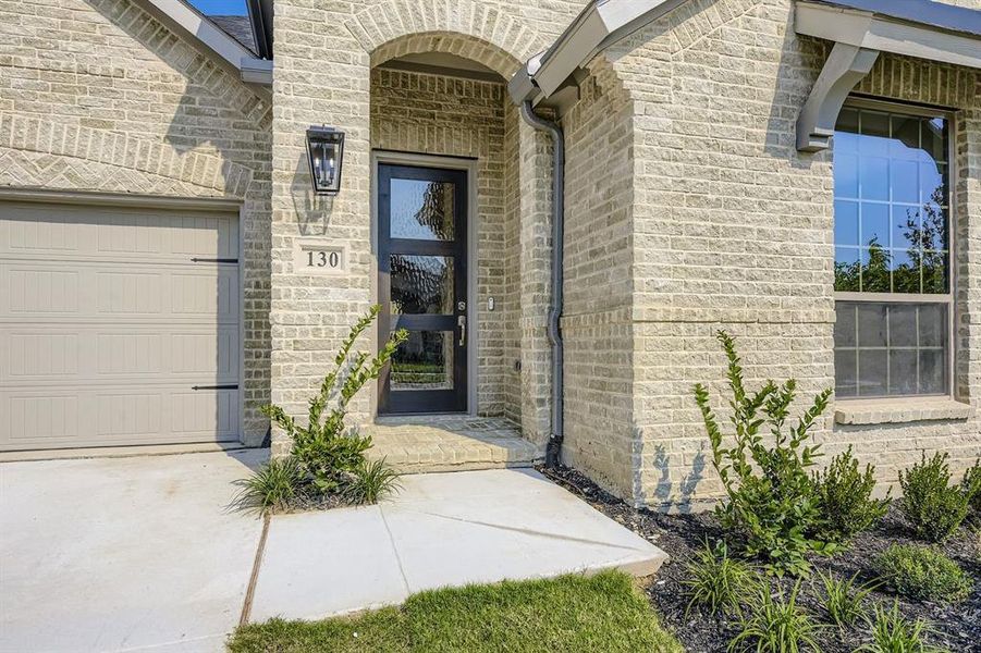 Doorway to property featuring brick siding and stone siding