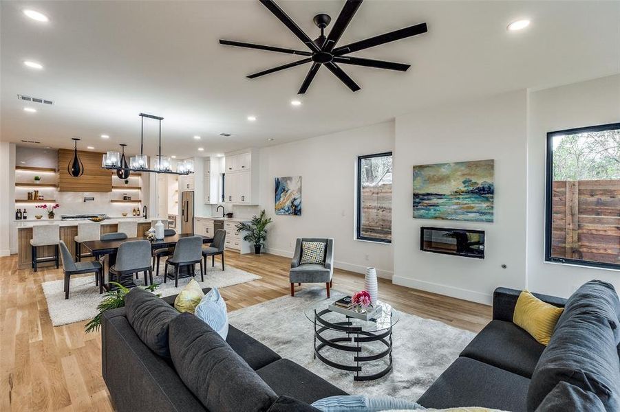 Living room with light hardwood / wood-style floors, ceiling fan, and sink