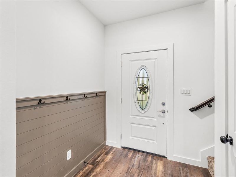 Entryway featuring dark wood finished floors and baseboards