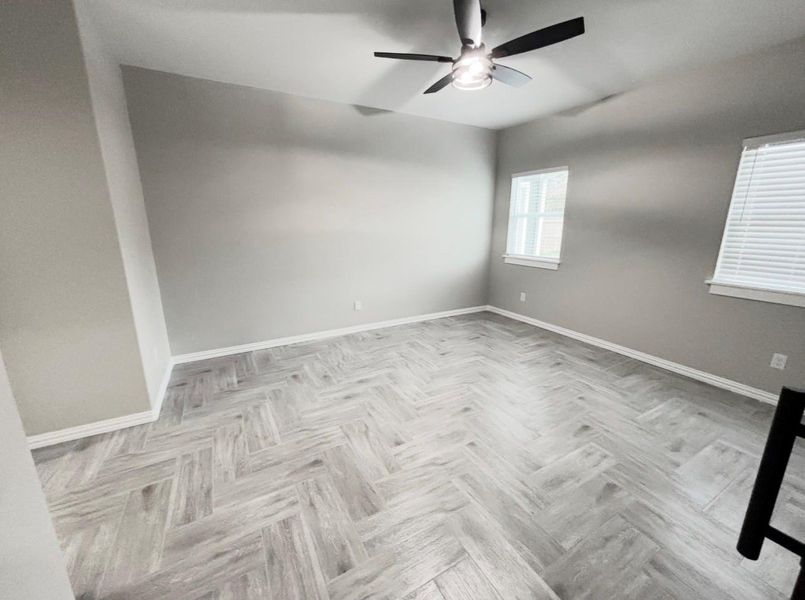 Spacious 16x15 primary bedroom with abundant natural light and modern flooring.