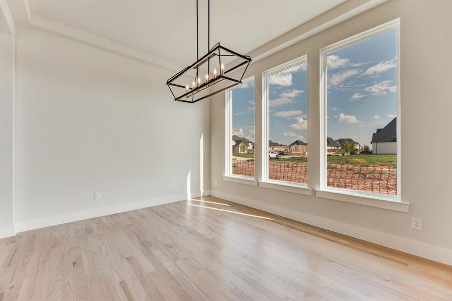 Unfurnished dining area featuring light wood-style flooring and a residential view Unfurnished dining area featuring light wood-style flooring and a residential view