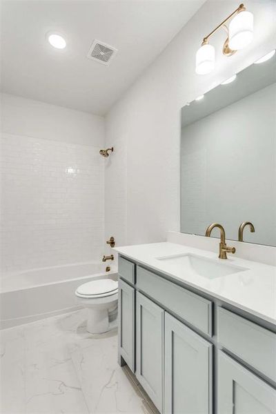 Bathroom featuring vanity, shower / bath combination, and marble finish flooring Bathroom featuring vanity, shower / bath combination, and marble finish flooring