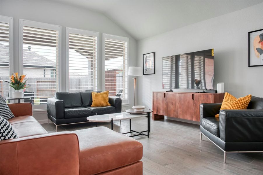 Modern living room with large windows and abundant natural light. Features stylish leather seating, a sleek TV stand, and contemporary decor. Modern living room with large windows and abundant natural light. Features stylish leather seating, a sleek TV stand, and contemporary decor.