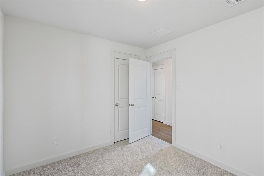 Spare room featuring light carpet and baseboards