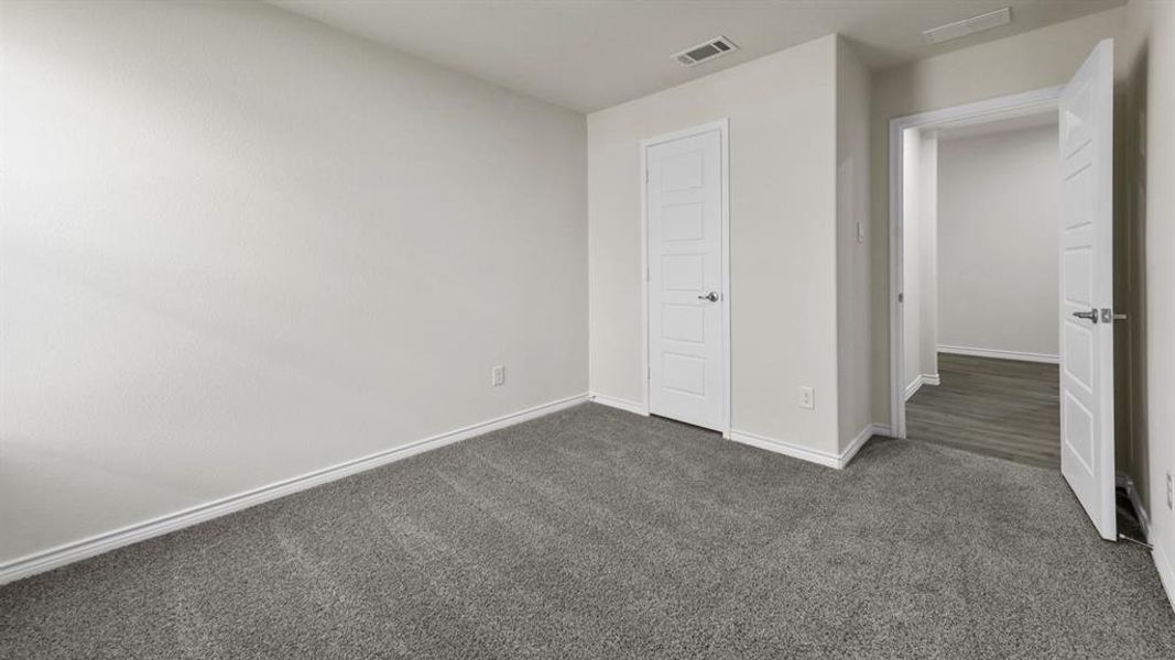Room featuring textured gray carpeting, white walls, and white trim