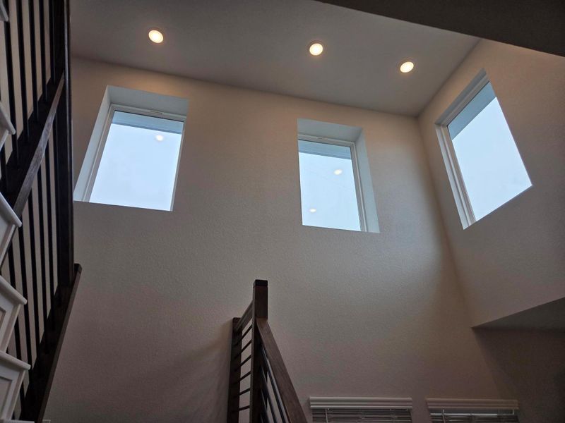 Two-story entryway with high windows and recessed lighting