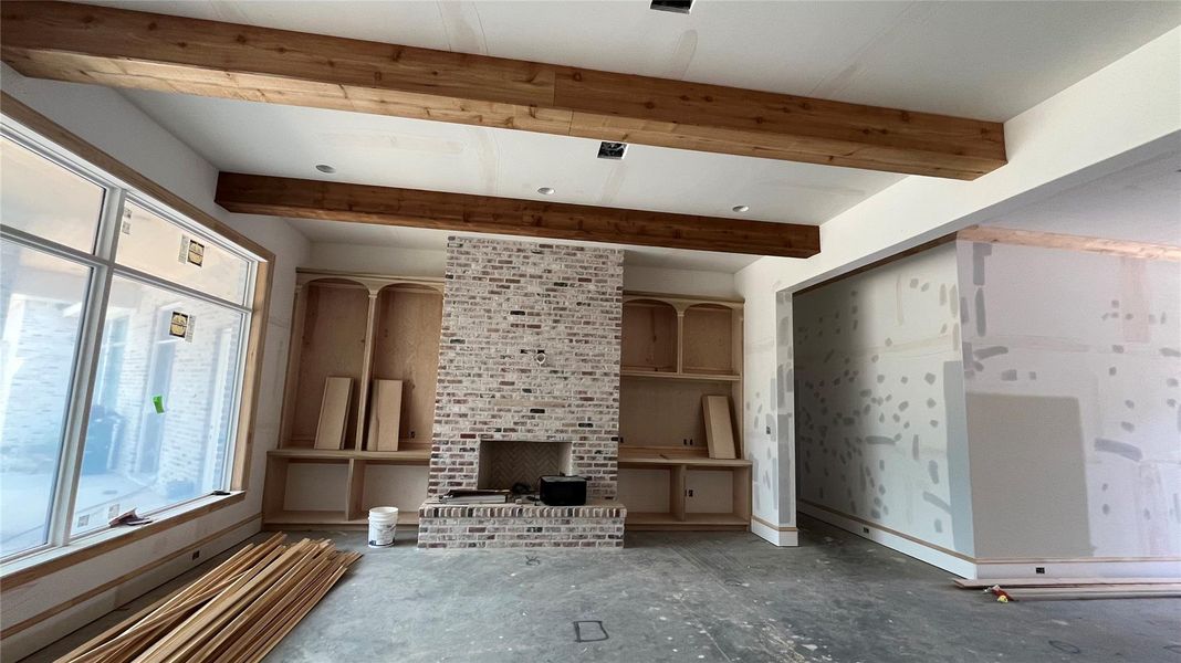 A progress photo in August 2025 showing the family room with custom cabinetry and beautiful fireplace.