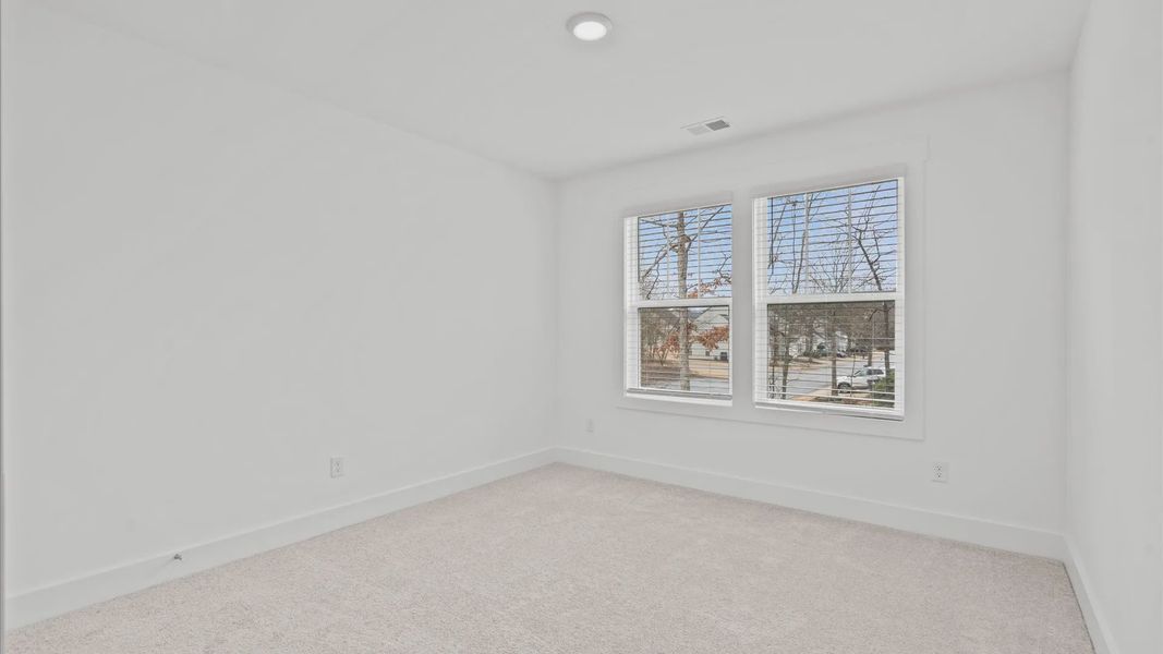 Accomplished bedroom layout with cozy carpet, a spacious walk-in closet, and sun-filled windows located at Pelham Crossing