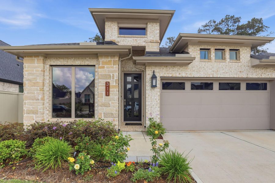 Natural stone textures and tiered rooflines create a warm, architectural welcome to the home.