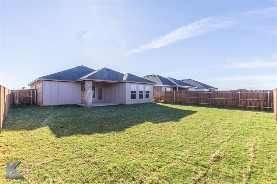 Rear view of property with a patio, with a fenced backyard.