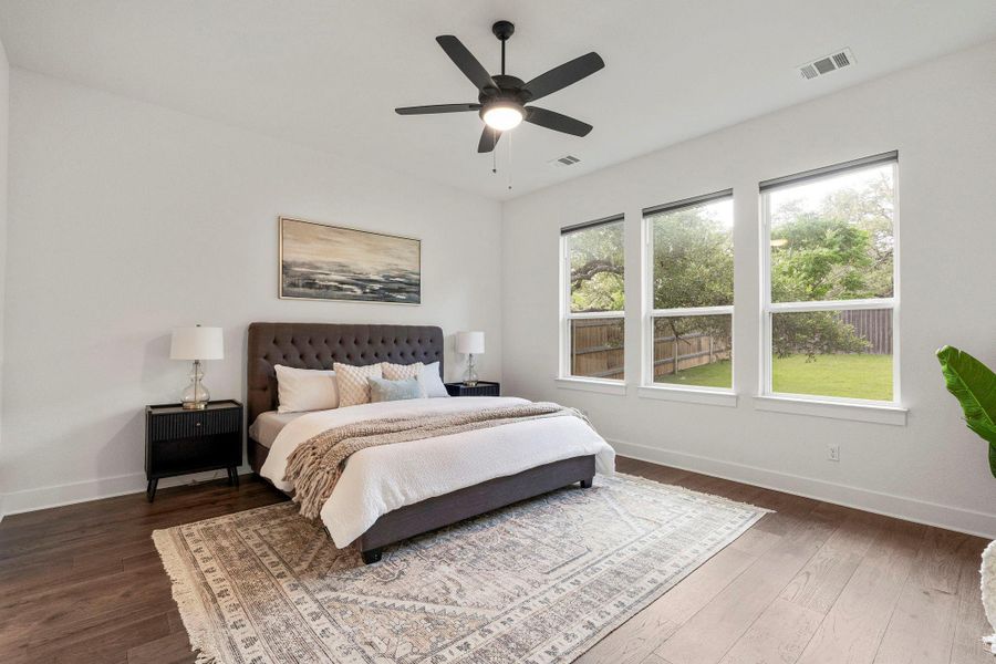 Hardwood floors and generous natural light create an inviting primary bedroom.
