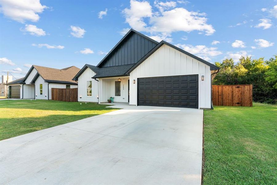 Modern farmhouse style home with a garage and a front yard