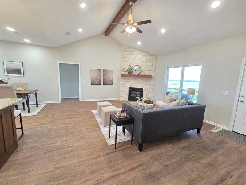 Living area featuring ceiling fan, beamed ceiling, a fireplace, wood finished floors, and recessed lighting Living area featuring ceiling fan, beamed ceiling, a fireplace, wood finished floors, and recessed lighting