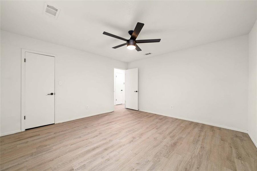 Unfurnished room featuring light wood-style floors, visible vents, ceiling fan, and baseboards Unfurnished room featuring light wood-style floors, visible vents, ceiling fan, and baseboards