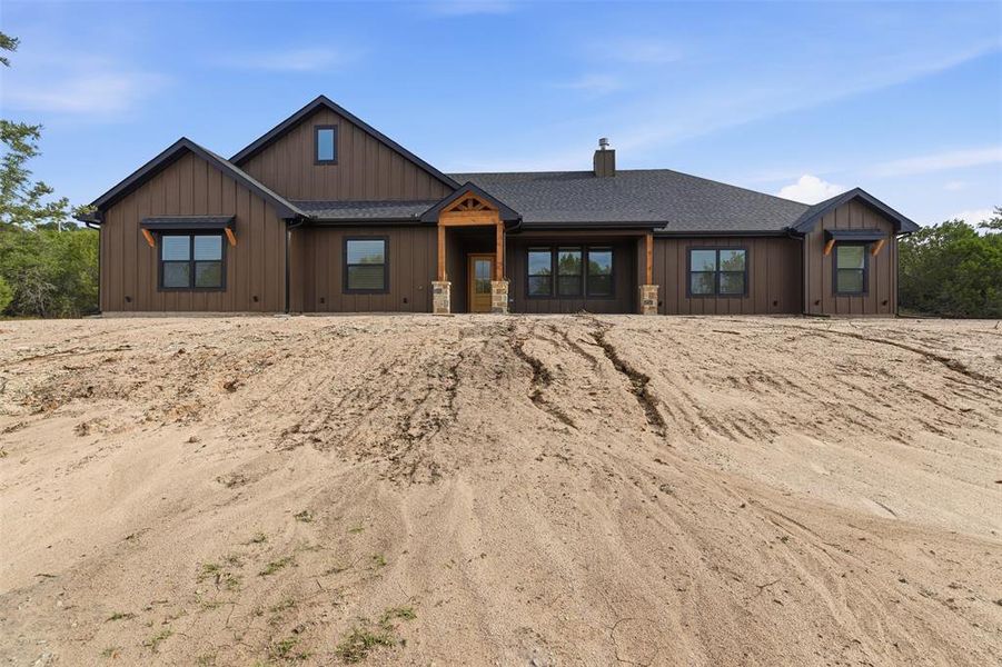 View of front of home with a shingled roof, board and batten siding, and a chimney View of front of home with a shingled roof, board and batten siding, and a chimney