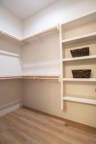 Walk in closet featuring wood finished floors Walk in closet featuring wood finished floors