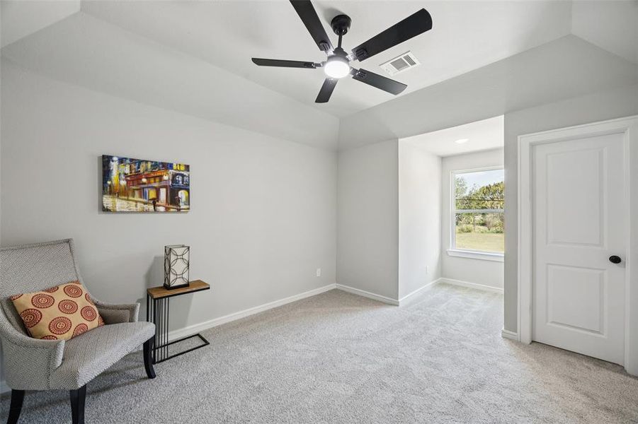Living area with light carpet, lofted ceiling, and ceiling fan