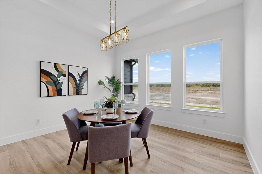 Dining area with light wood-type flooring and a chandelier