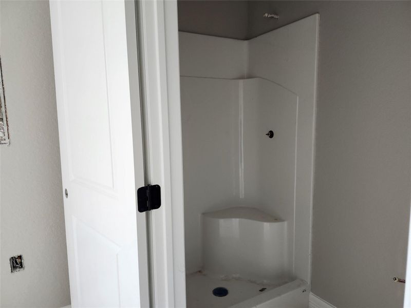 This photo shows a shower area with a built-in seat. The walls are painted in a neutral tone.