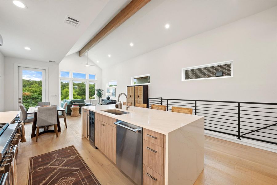 An open-concept living space with vaulted ceilings, generous natural light, and a functional kitchen island. An open-concept living space with vaulted ceilings, generous natural light, and a functional kitchen island.