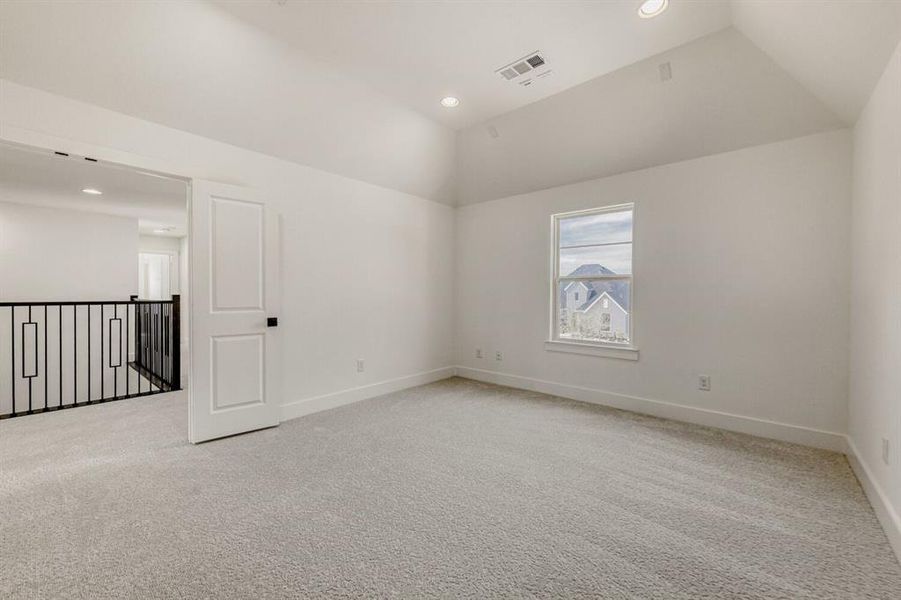 Unfurnished room with light colored carpet, lofted ceiling, and recessed lighting