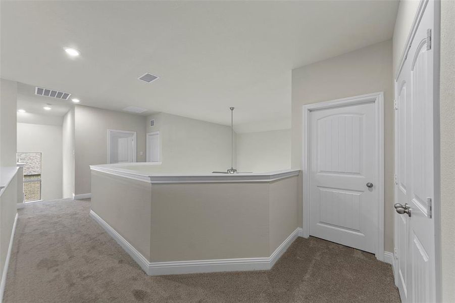 Hallway with carpet floors, recessed lighting, and an upstairs landing Hallway with carpet floors, recessed lighting, and an upstairs landing