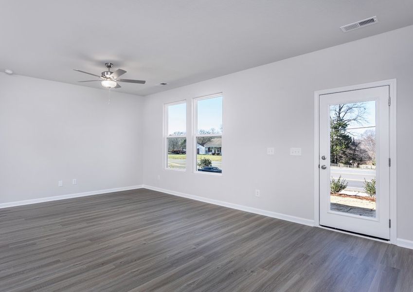 The living room has lots of space and windows that let in lots of natural light