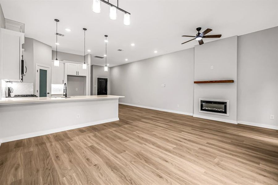 Another view of the breakfast bar, fireplace and entry way beyond.