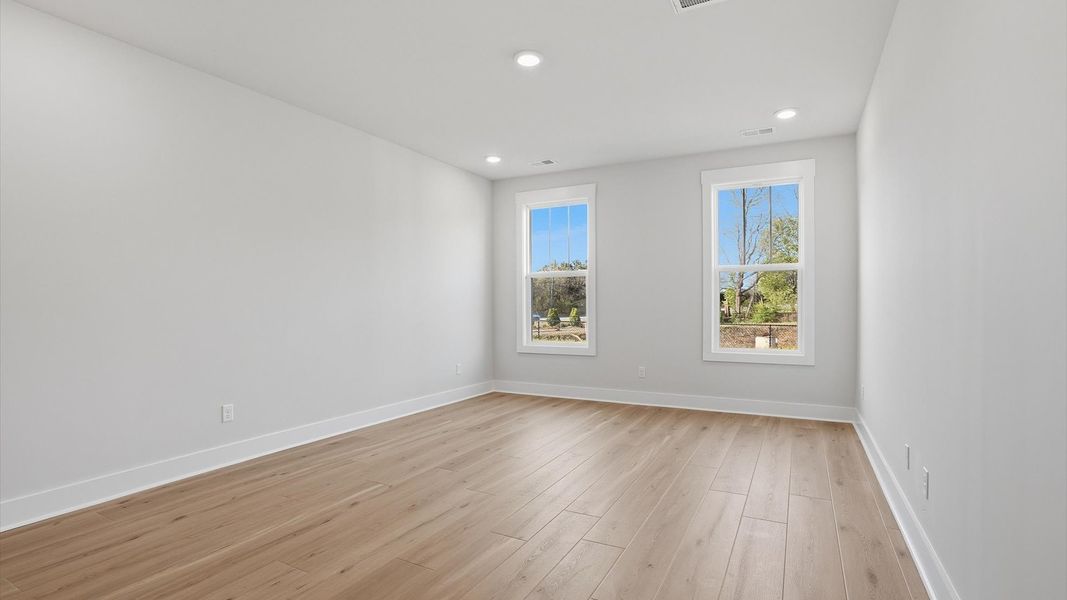 Serene and stylish primary bedroom featuring hardwood flooring and a thoughtful, modern layout at Pelham Crossing