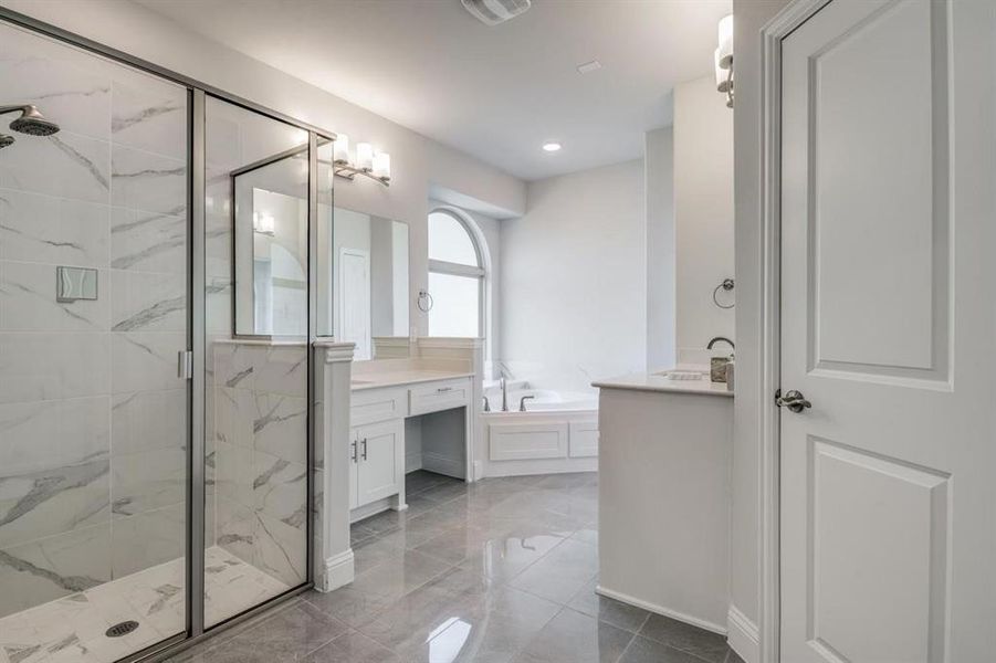 Bathroom featuring vanity and independent shower and bath