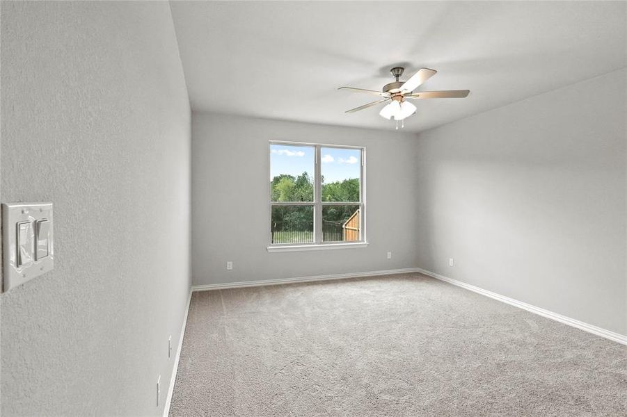 Spare room featuring carpet and ceiling fan