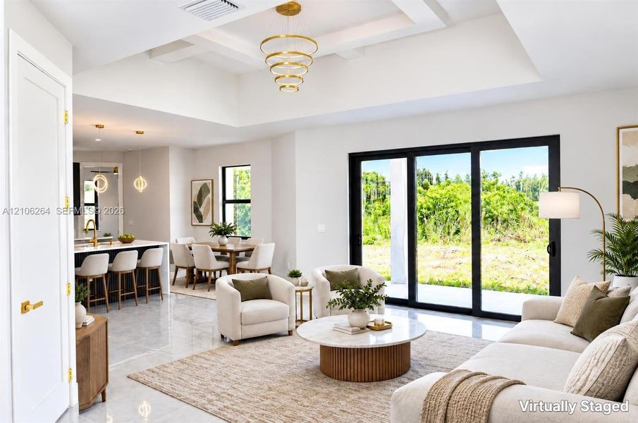 Tray ceiling with tiered gold-finish chandelier, large-format tile flooring, and oversized sliding glass doors