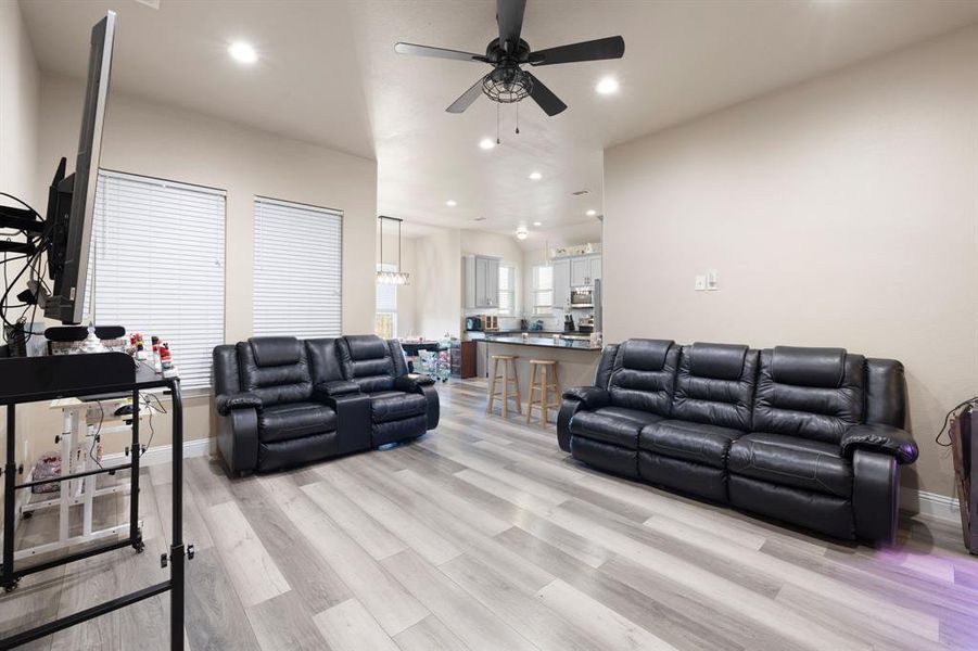 Living room with light wood-type flooring and ceiling fan