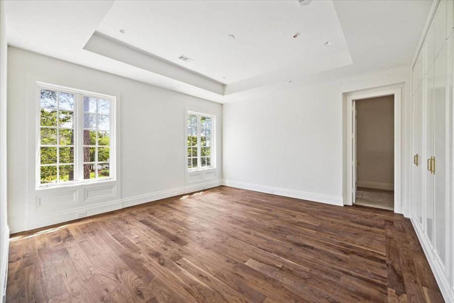 This secondary bedroom features a raised ceiling, en-suite bathroom, and walk-in closet.