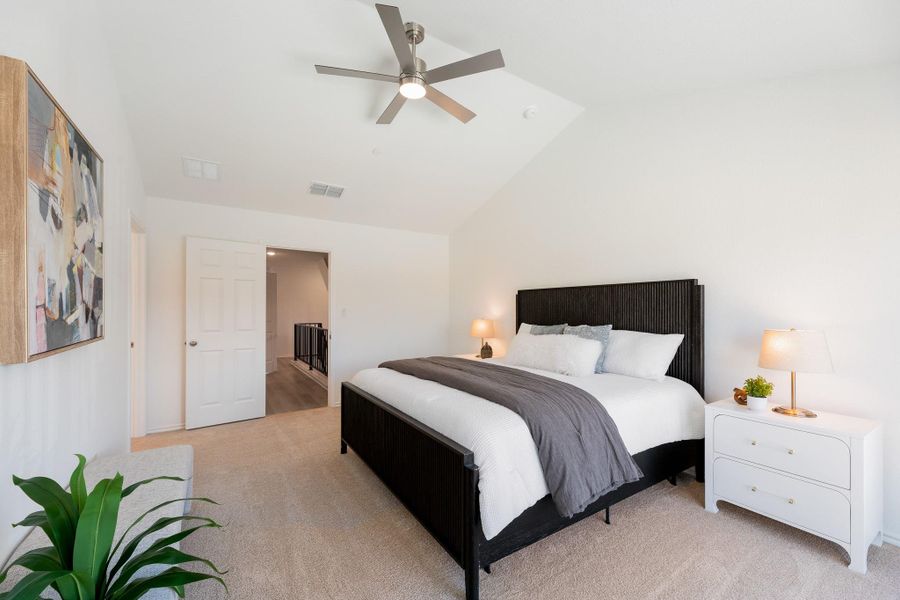 Bedroom featuring light carpet, lofted ceiling, and a ceiling fan
