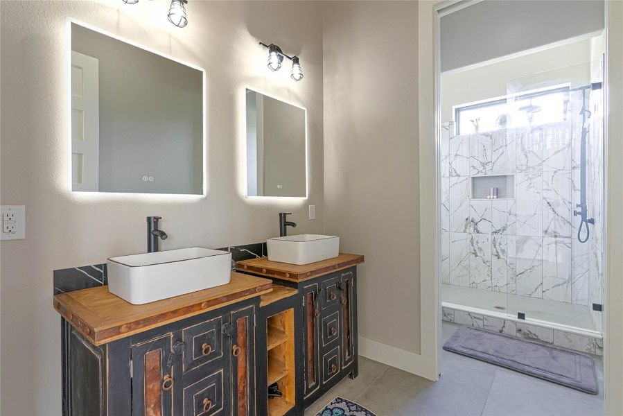 Stylish secondary bath with dual vanities and walk-in shower.
