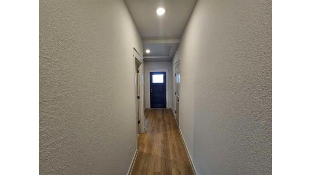 Hallway featuring wood-finish flooring, recessed lighting, and a coffered ceiling detail Hallway featuring wood-finish flooring, recessed lighting, and a coffered ceiling detail
