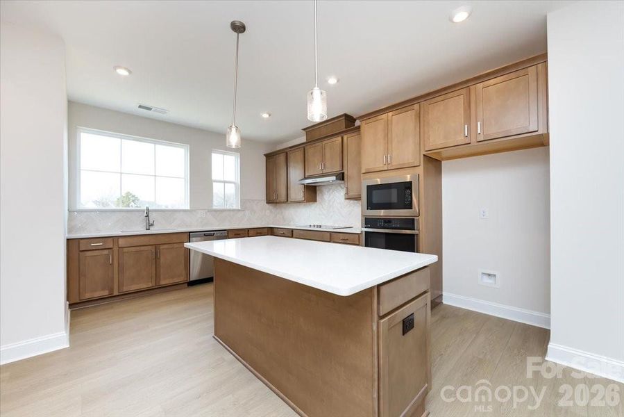 Gourmet kitchen with warm brown cabinets
