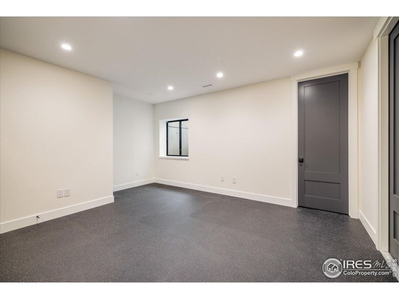 Basement work-out room with rubber flooring and access to unfinished storage space