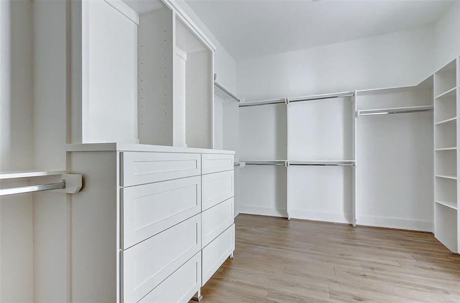 This dream walk-in closet with custom built-ins offers an abundance of space for a large annual wardrobe for TWO!